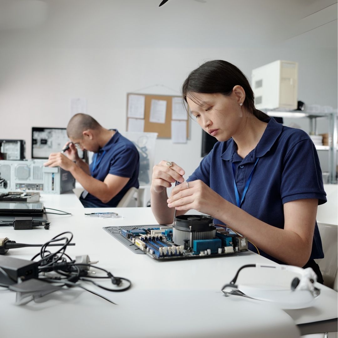 Technicians assembling circuit boards in a tech lab — electronics industry staffing solutions.