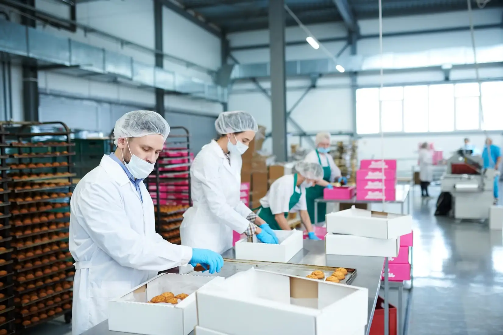 Food production staff hired by FMCG recruiters packaging baked goods in a modern facility.