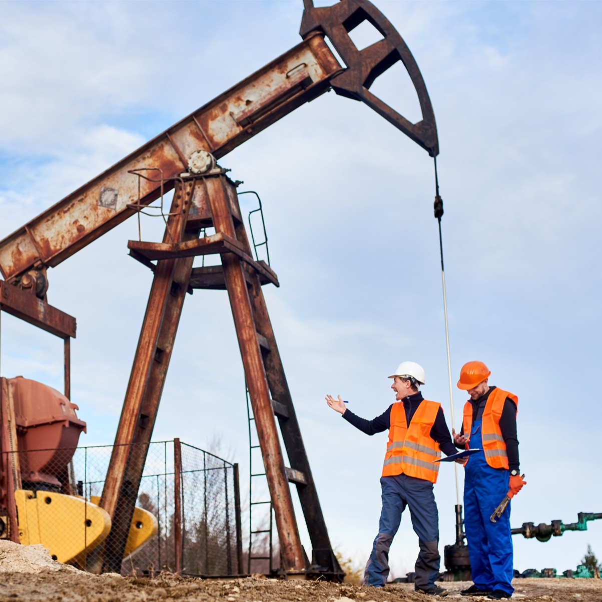 Engineers in safety gear reviewing plans at a renewable energy site — infrastructure and energy staffing services.