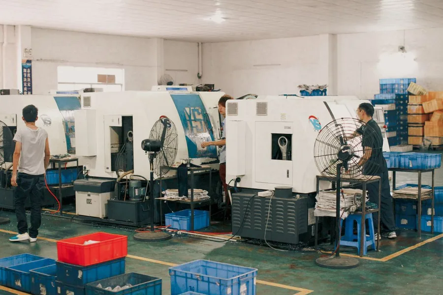 Factory workers operating machinery on a production floor